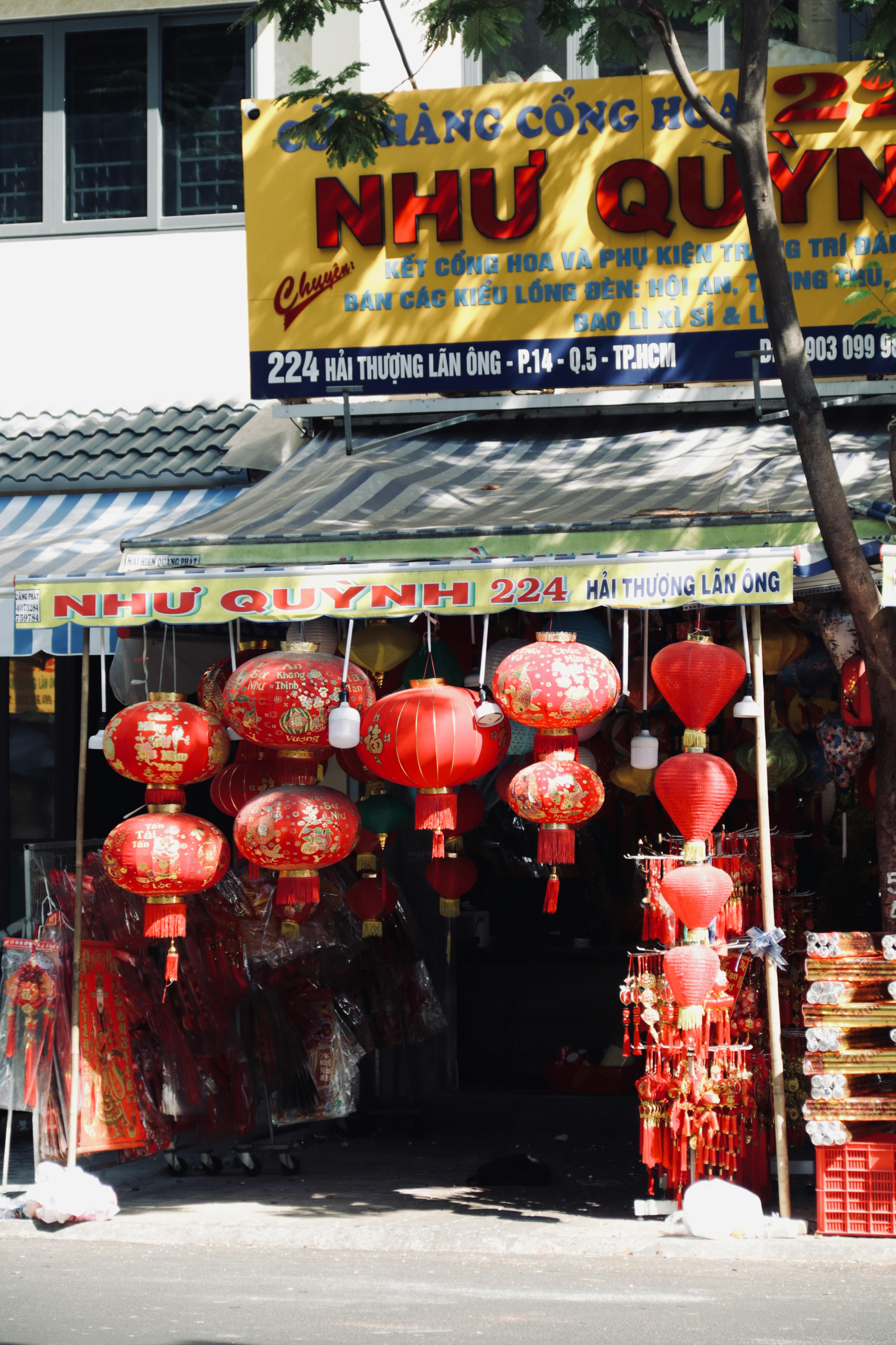 Street view of a vibrant Vietnamese market shop adorned with red lanterns.