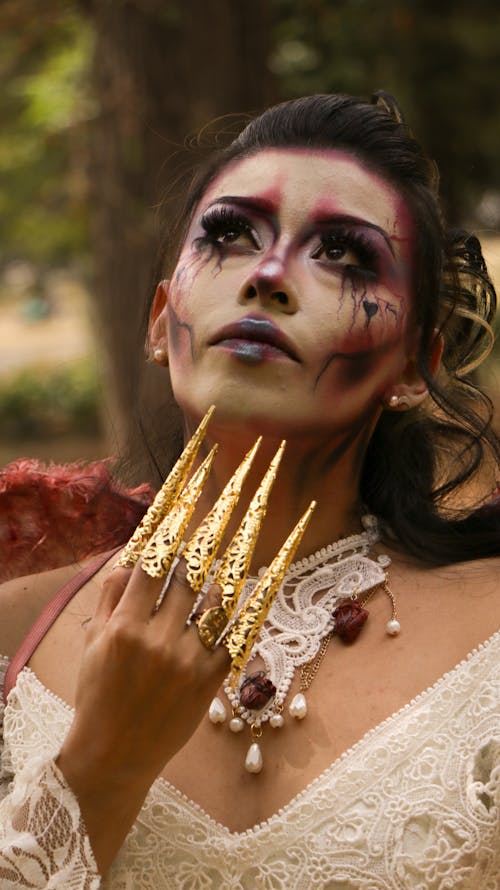 Portrait of Brunette Woman with Golden Nails and with Cosplay Makeup