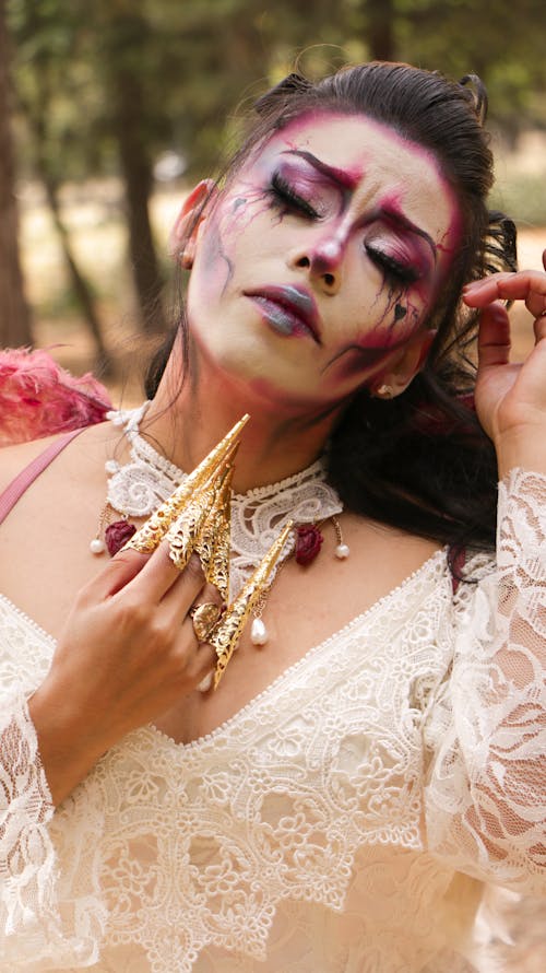 Female Model Wearing a White Dress and Face Paint