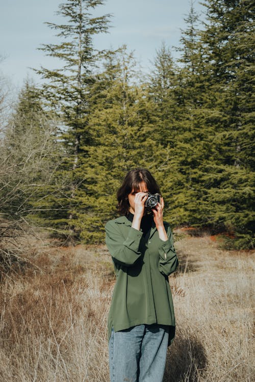 A woman taking a picture in the woods