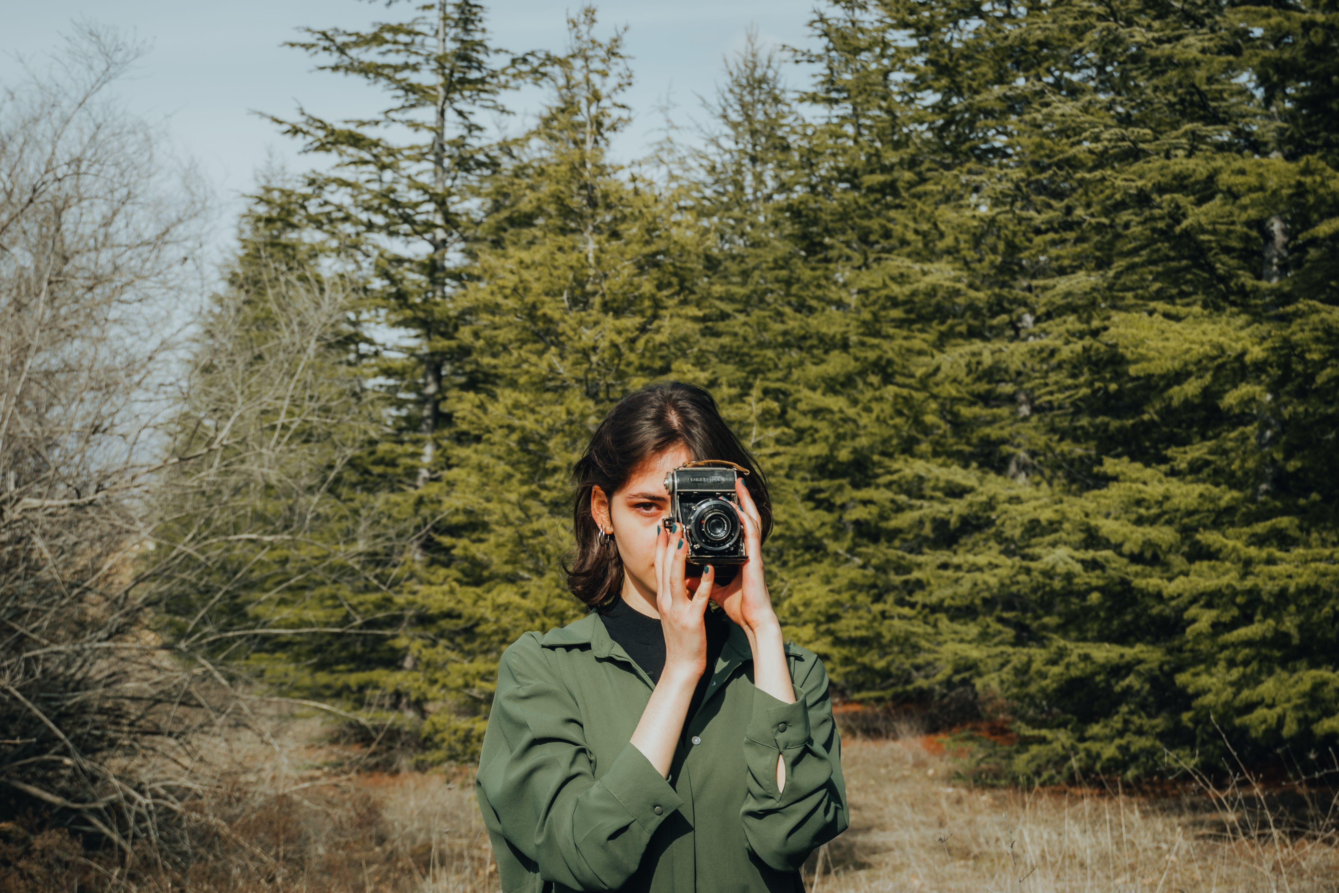 A woman taking a photo in the woods · Free Stock Photo