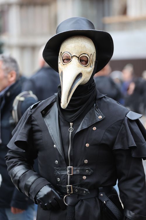 Free Plague doctor cosplay with mask and hat in urban setting. Stock Photo