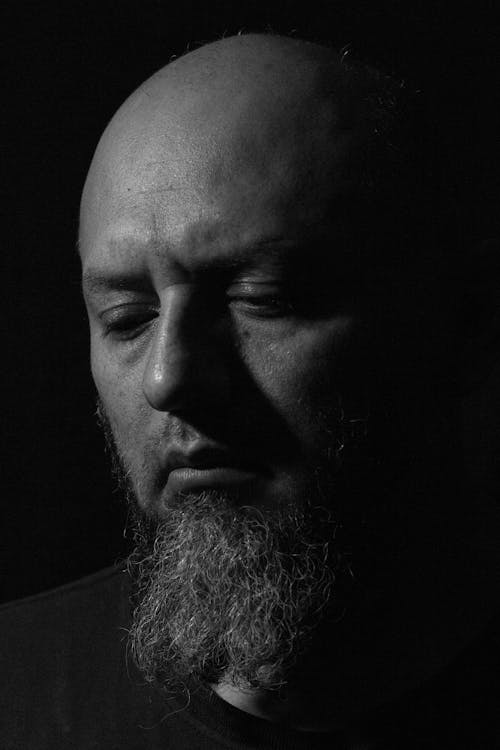 Portrait of a Bald Bearded Man Looking Down 