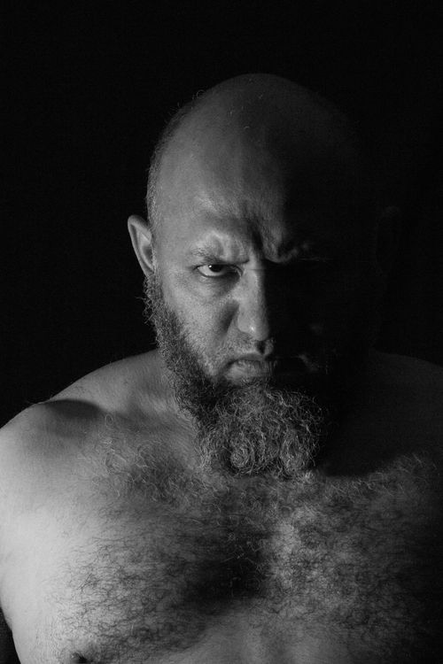 Free Grayscale close-up portrait of a bald man with a beard, capturing a fierce facial expression. Stock Photo