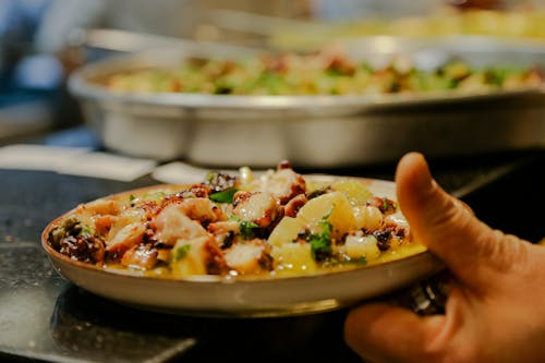 A person holding a plate of food in front of a buffet