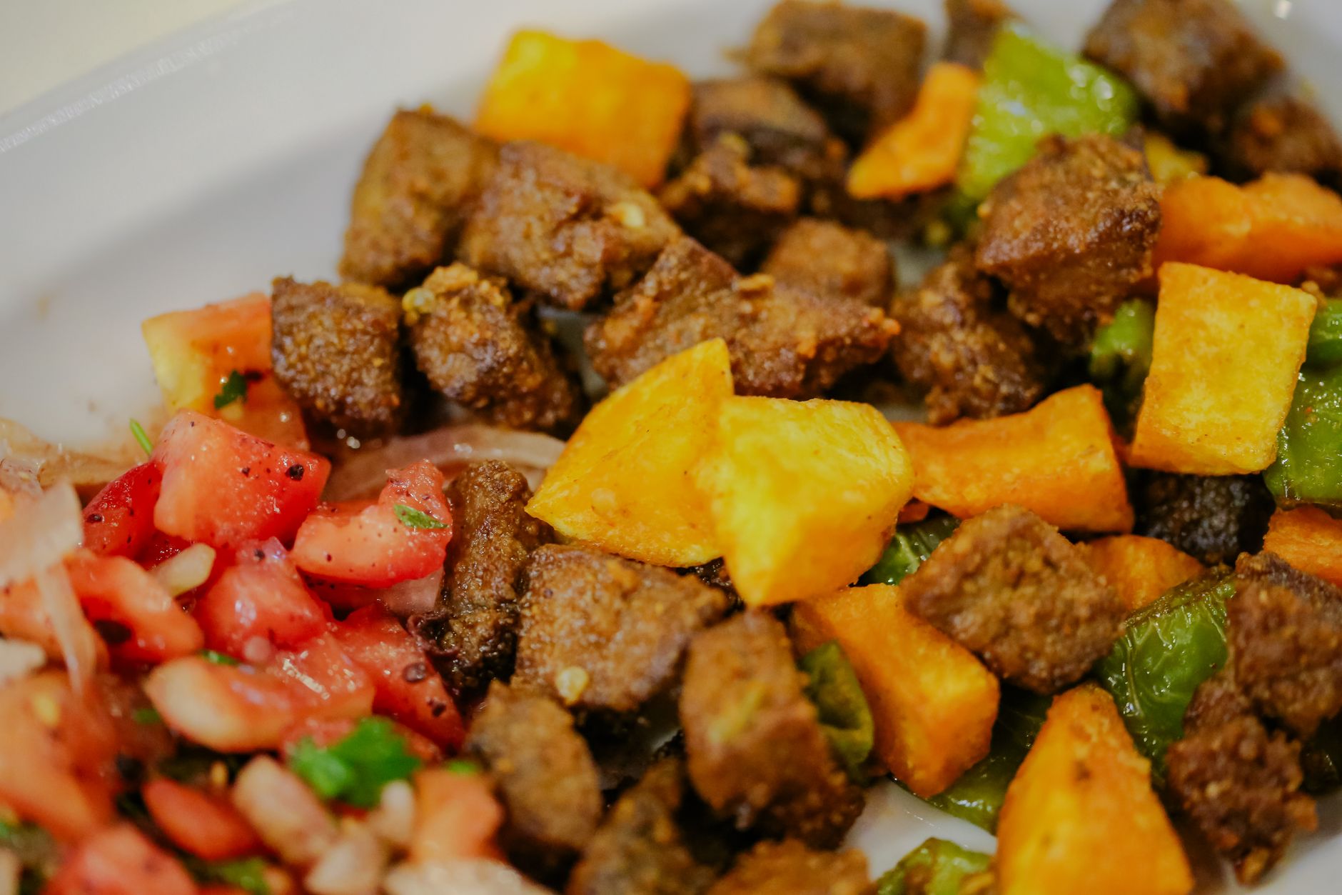 Assiette gourmande de Griot haïtien avec bananes pesées et pikliz