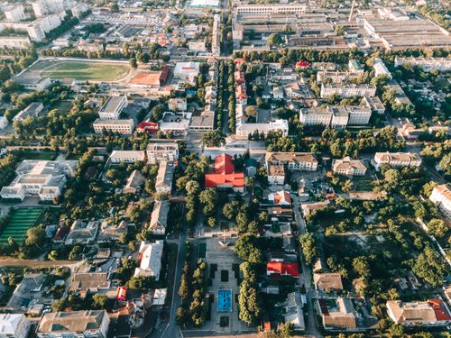 Free High-angle aerial view of a vibrant urban townscape with buildings and trees. Stock Photo