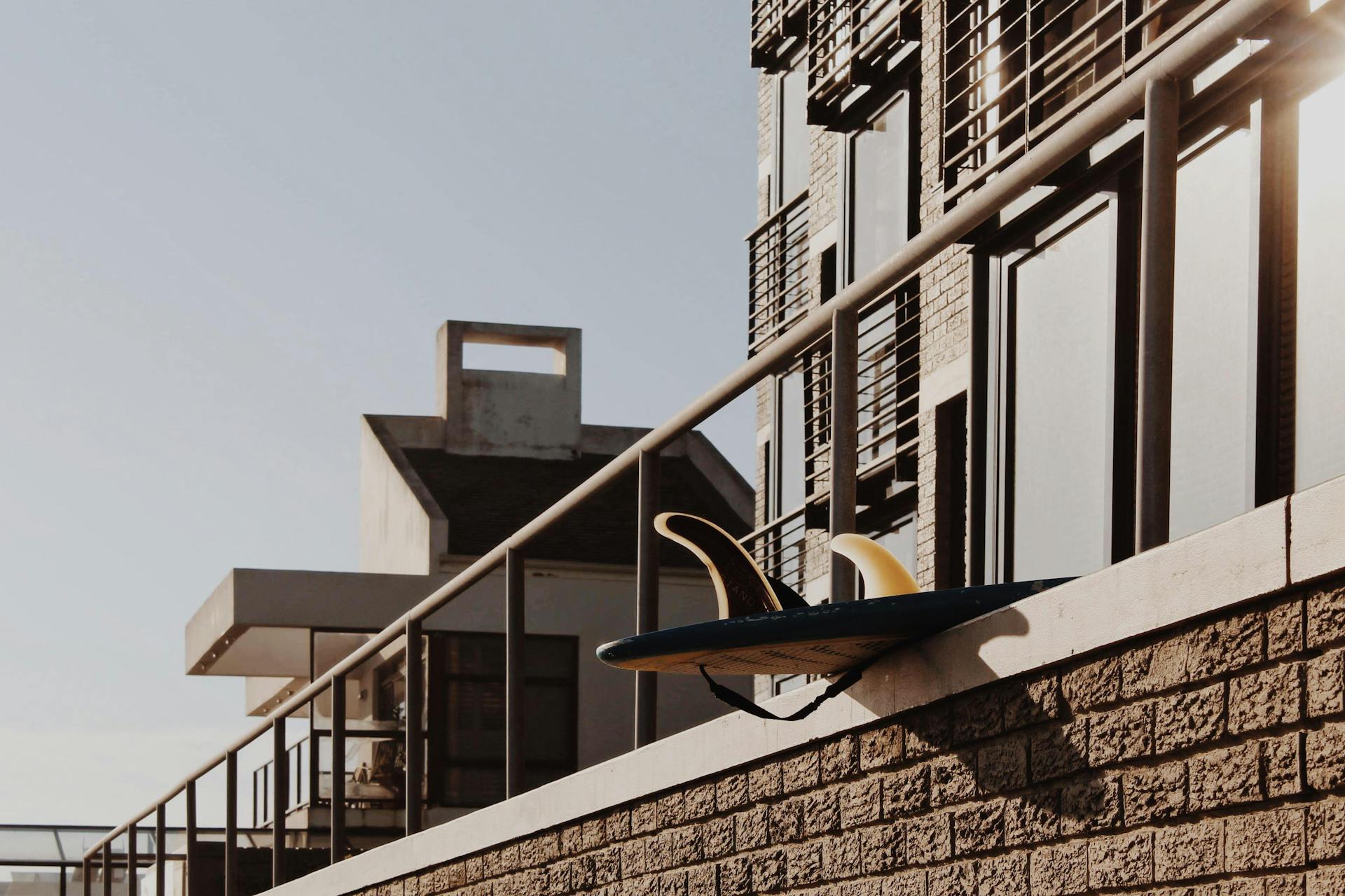 Contemporary building railings in Cape Town with a surfboard placed artistically on the ledge.