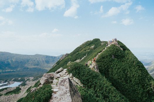 Hikers explore the scenic Koscielec Mountain in Zakopane, Poland, during a summer adventure.