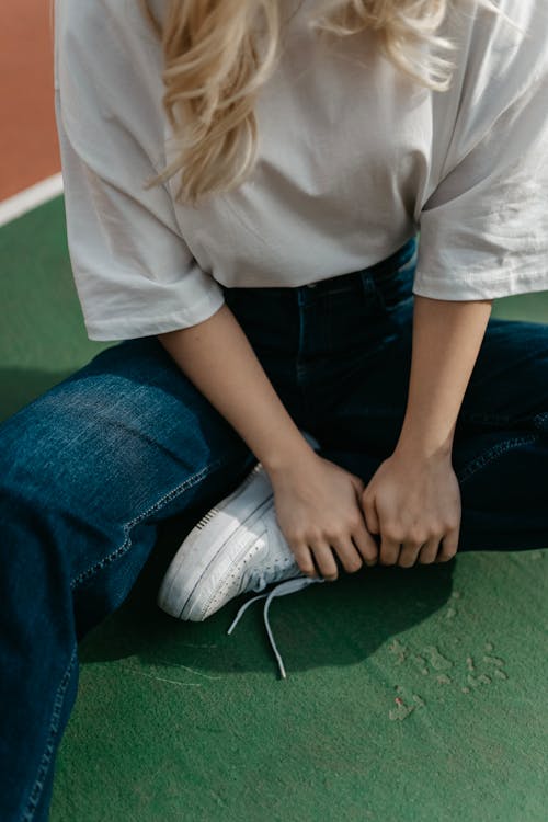 A woman sitting on the ground with her feet on the ground