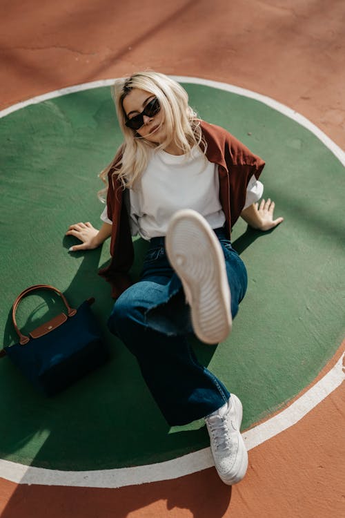 A woman laying on the ground with her sunglasses on