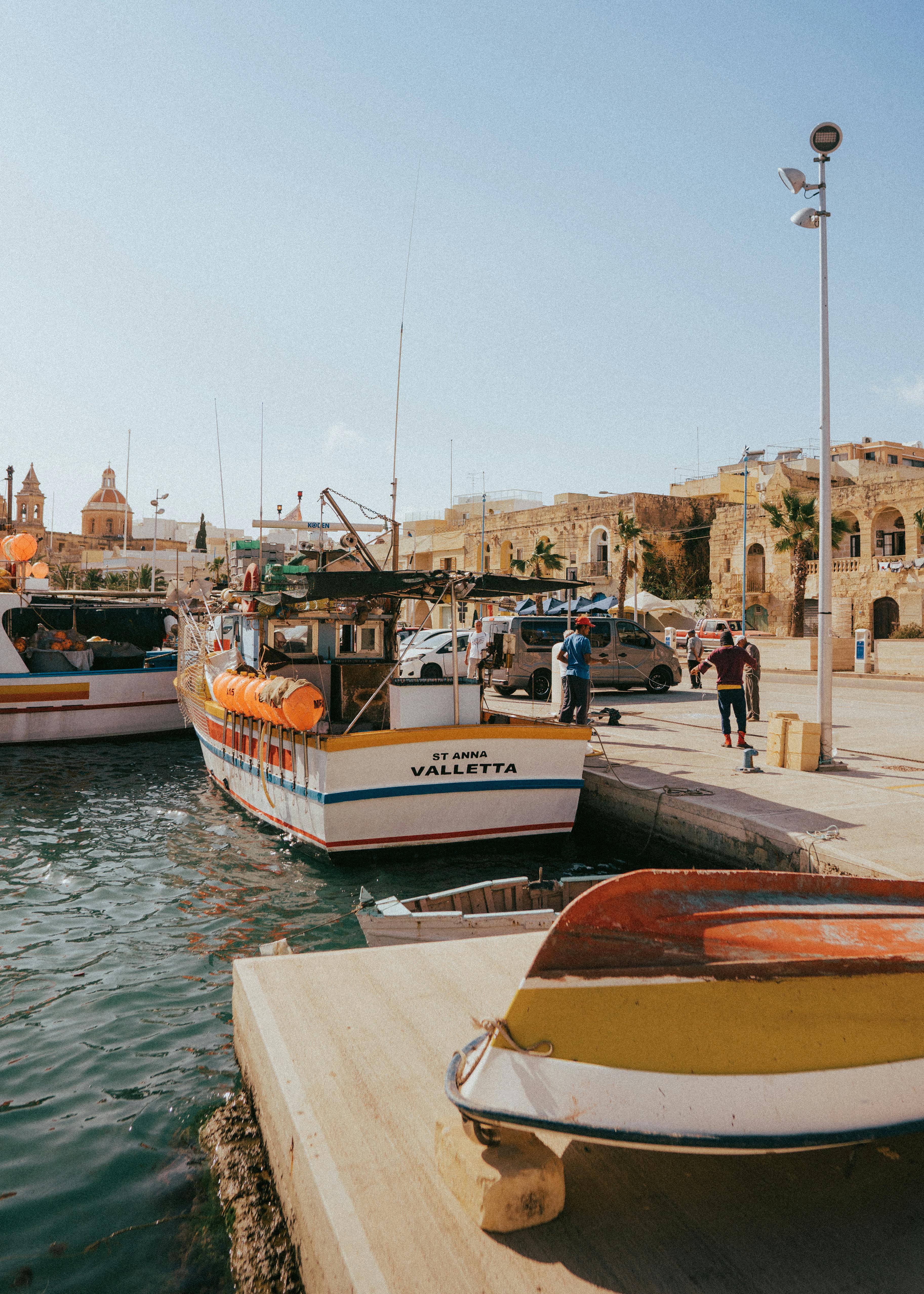 Vibrant boats docked in picturesque Marsašlokas harbor, showcasing traditional Maltese culture.