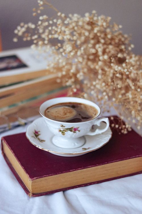 Free A soothing coffee break scene with a delicate porcelain cup on a book among dried flowers. Stock Photo