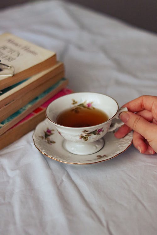 Elegant Porcelain Cup of Tea on Table by Books