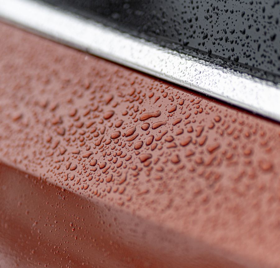 Water beading on a glossy car surface