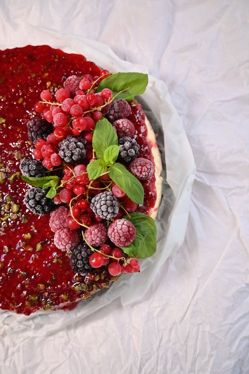 A cake with berries and mint leaves on top
