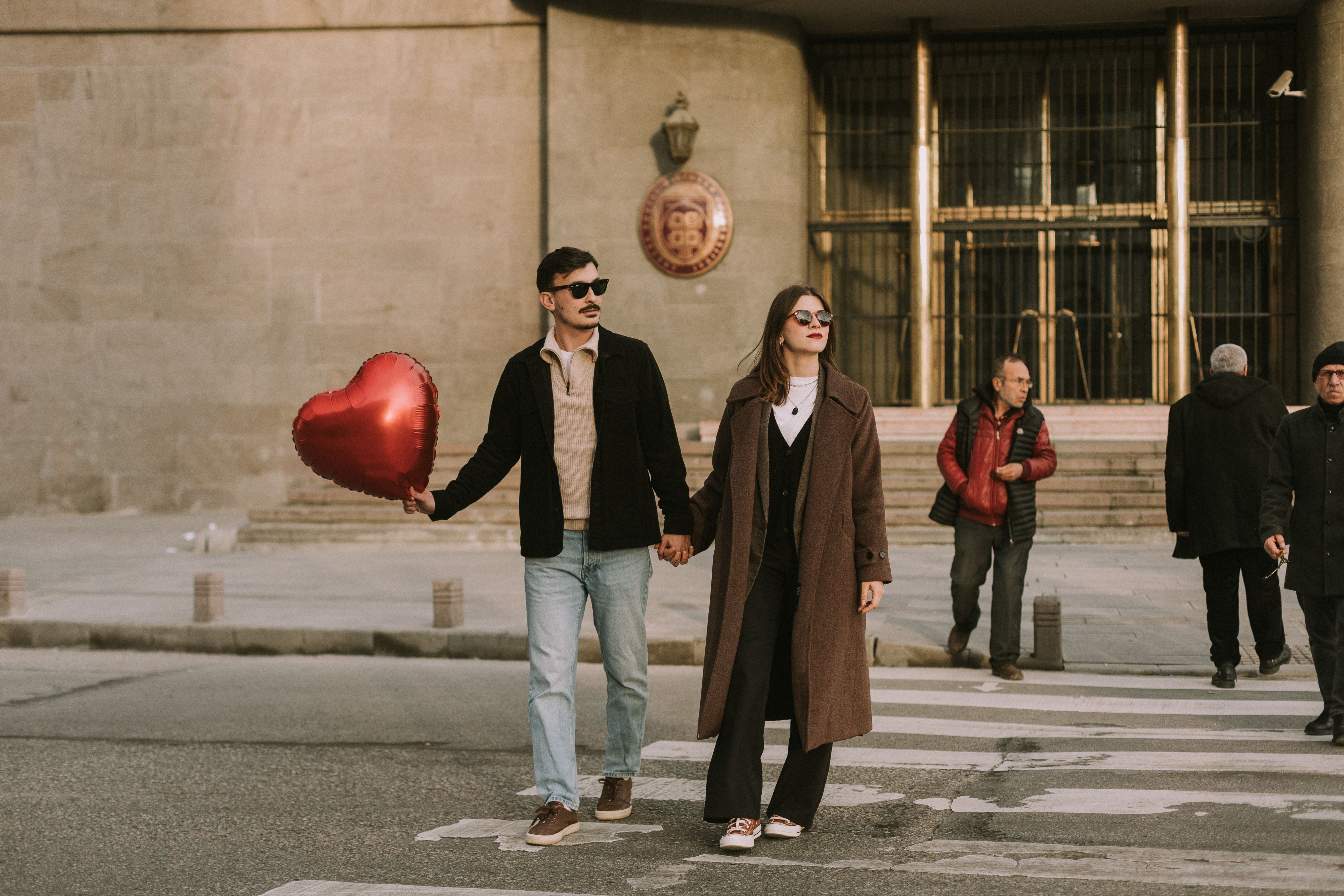 A Couple Holding a Heart Shaped Balloon Crossing the Street in City ...