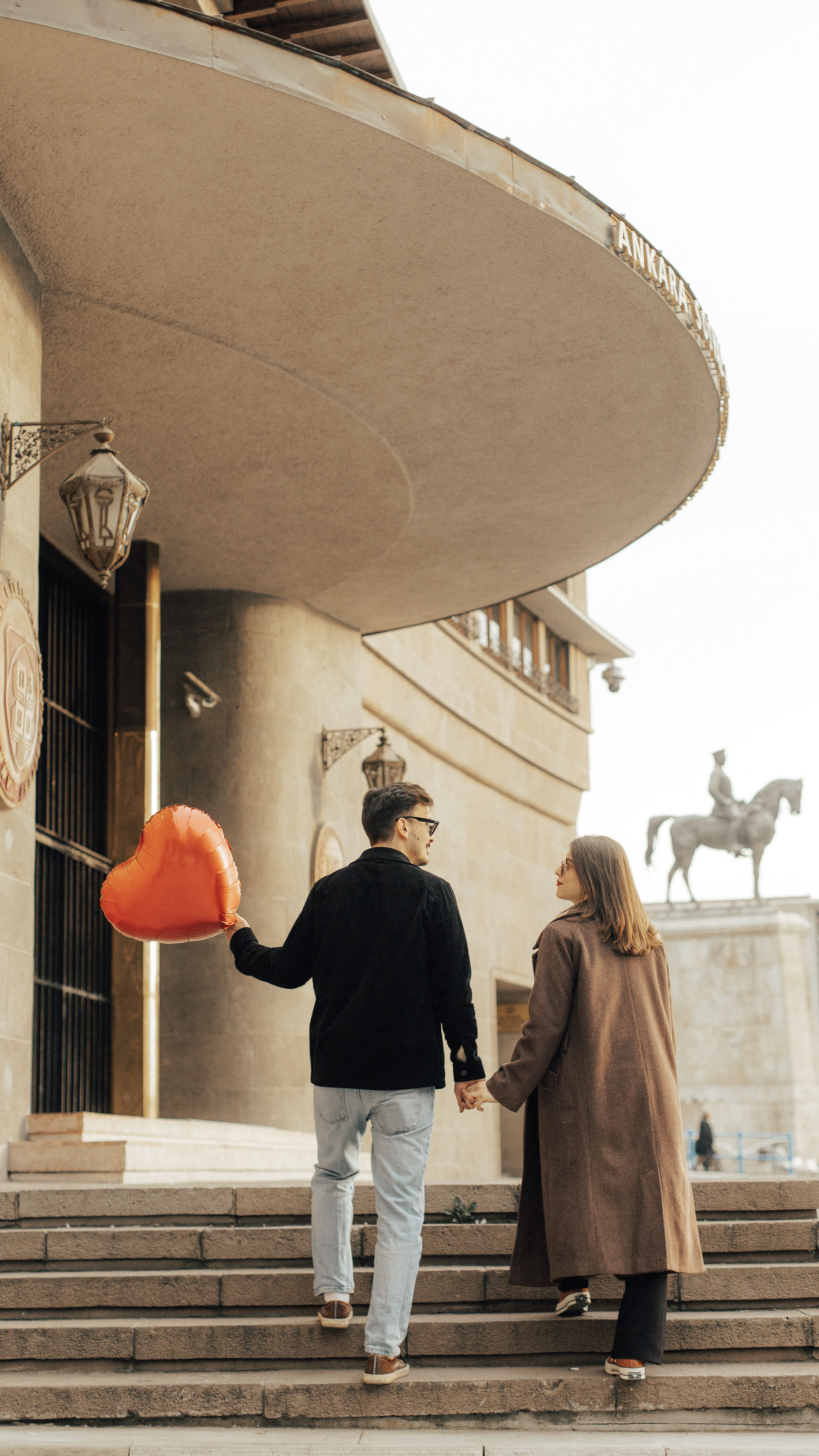 A Couple Holding a Heart Shaped Balloon Walking on Steps in City · Free ...