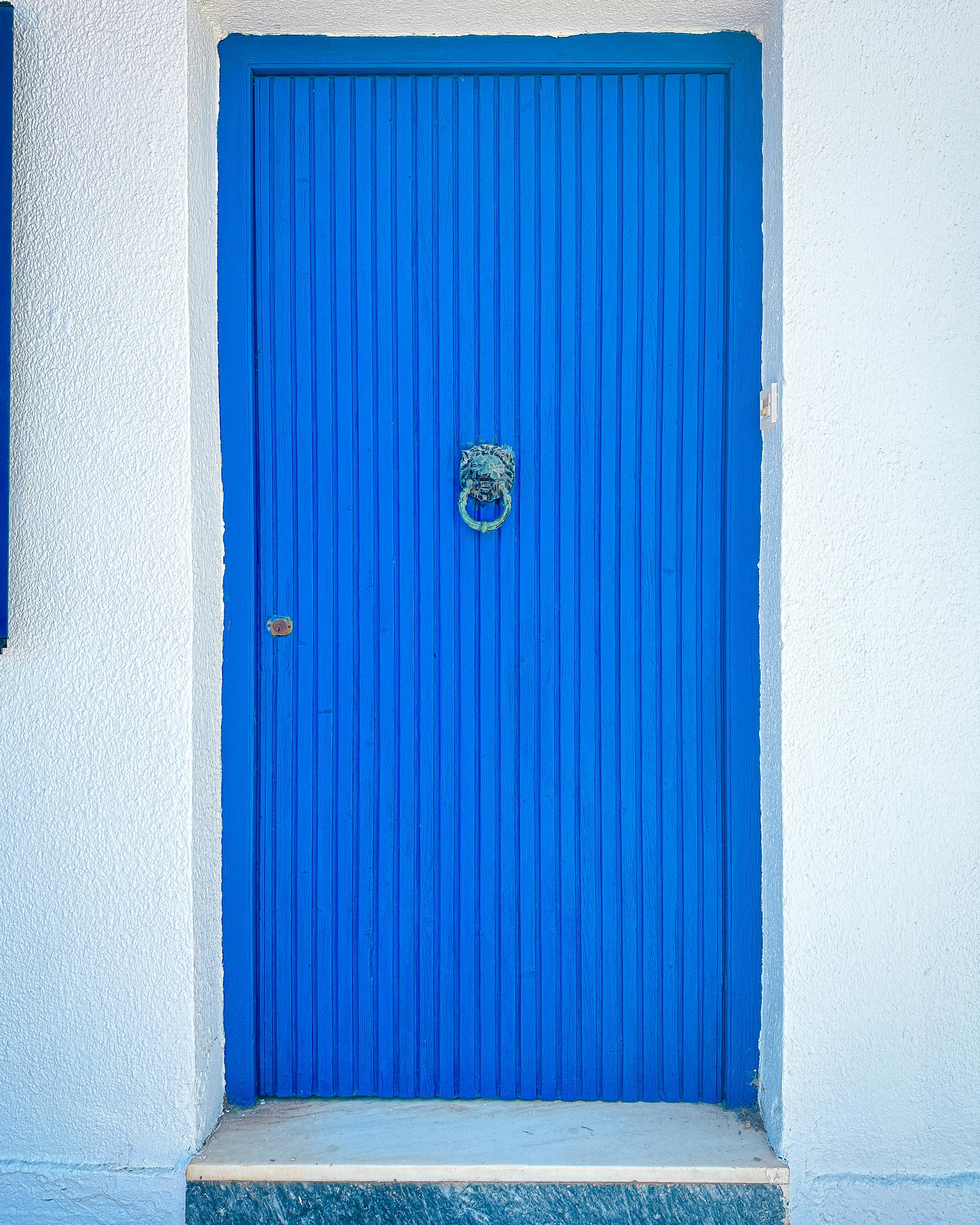 Free Vibrant blue door on a white wall in Methoni, Greece, showcasing classic Mediterranean architecture. Stock Photo