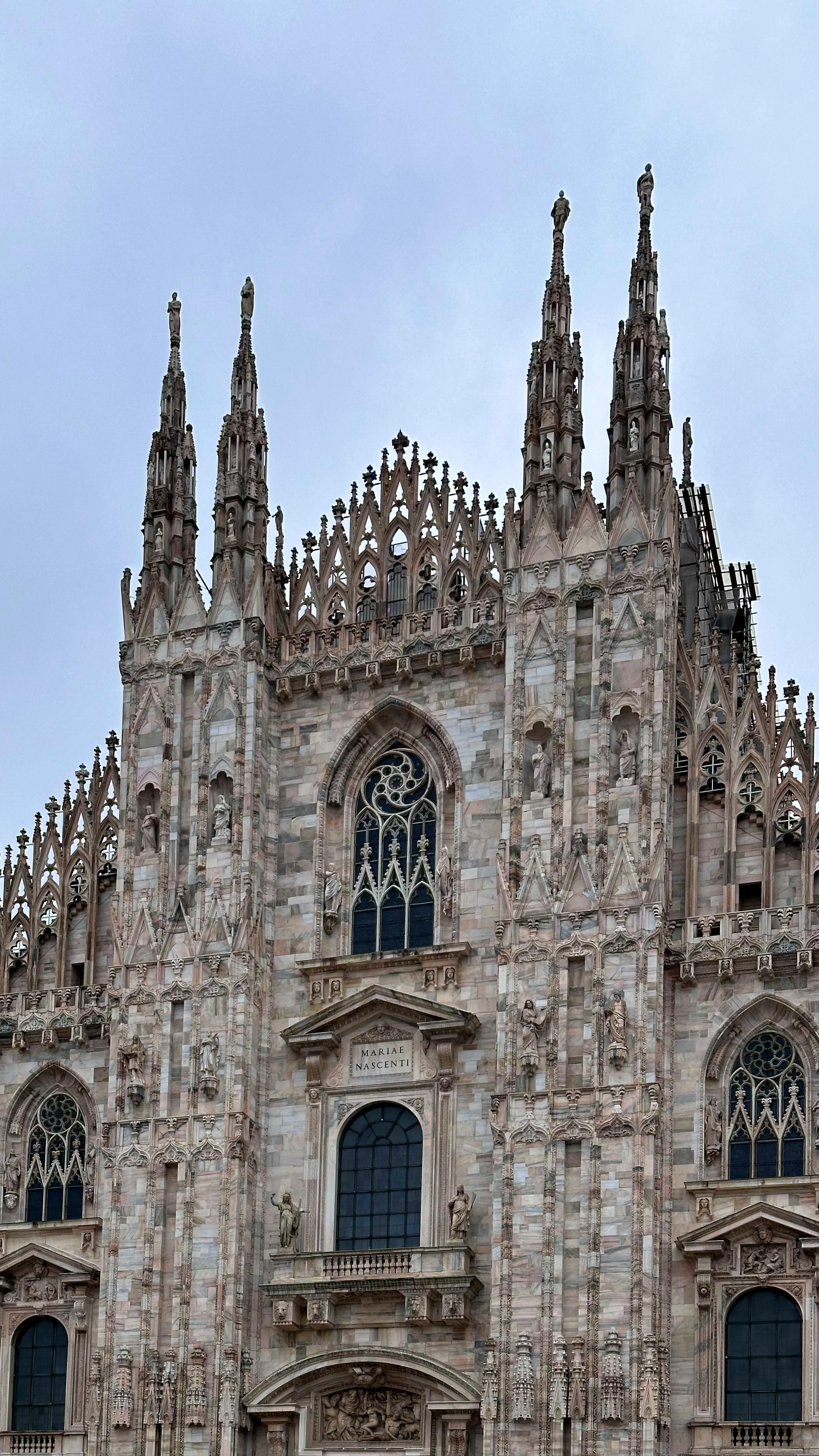 Close-up of Milan Cathedral's ornate Gothic facade showcasing intricate spires and architecture.