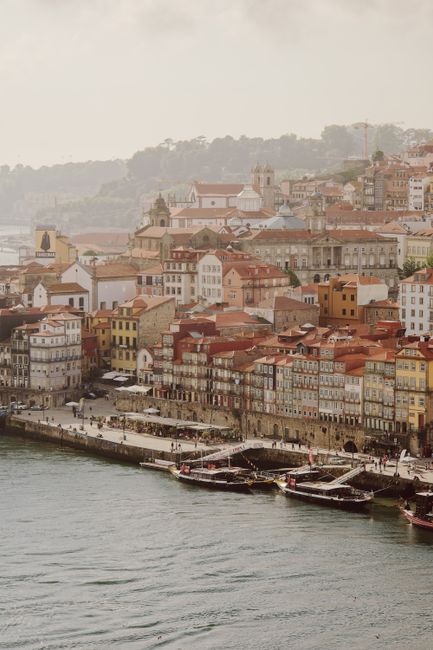 A stunning aerial view of Porto's historic waterfront with traditional boats and colorful buildings.