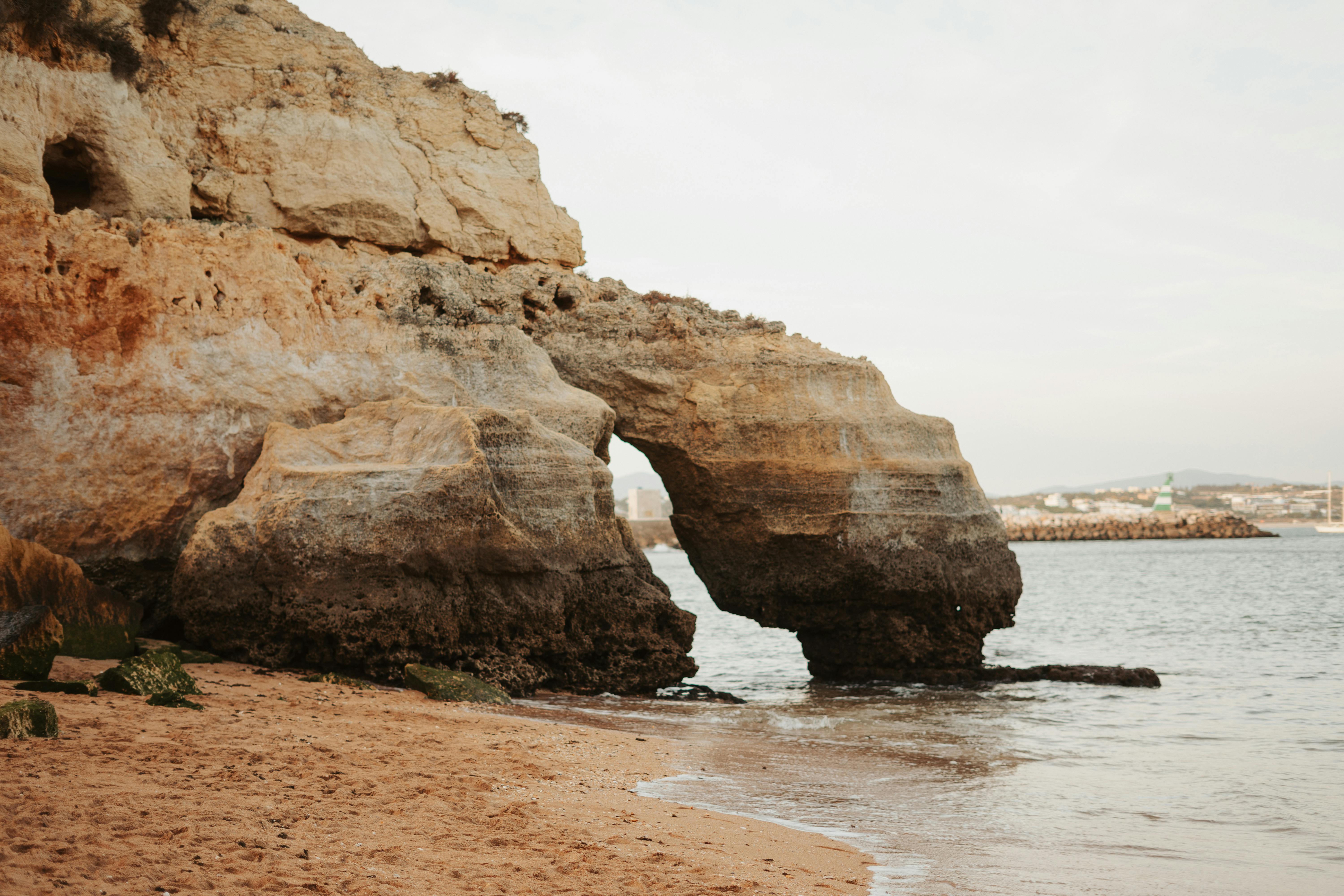 Stunning natural arch rock formation on coastal beach shoreline, perfect seascape scene.