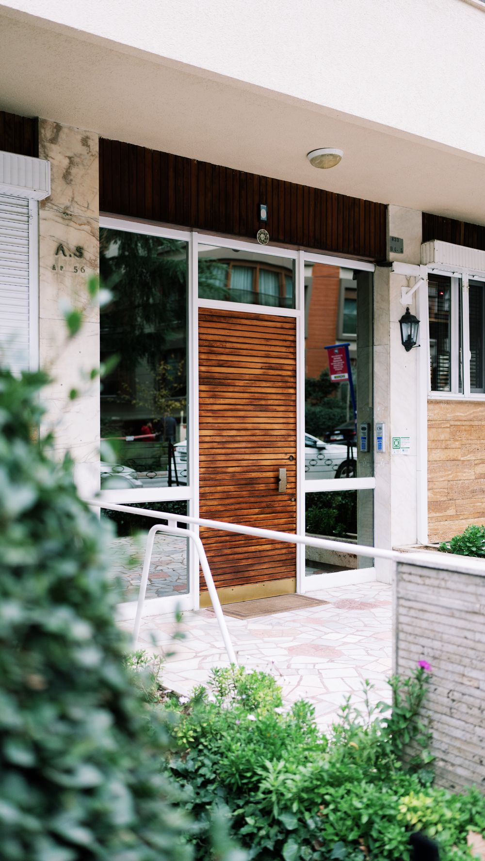 Entrada urbana contemporânea com porta de madeira