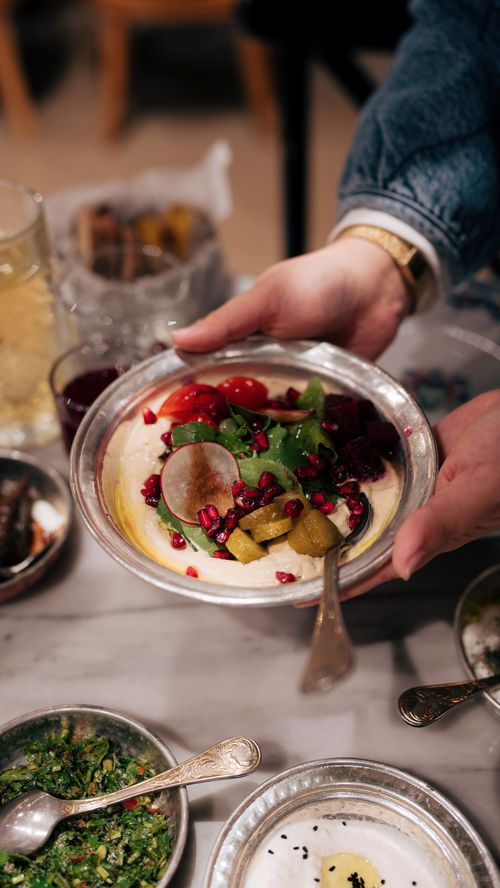 Free Close-up of hands holding a bowl of fresh Turkish meze in an İstanbul restaurant setting. Stock Photo