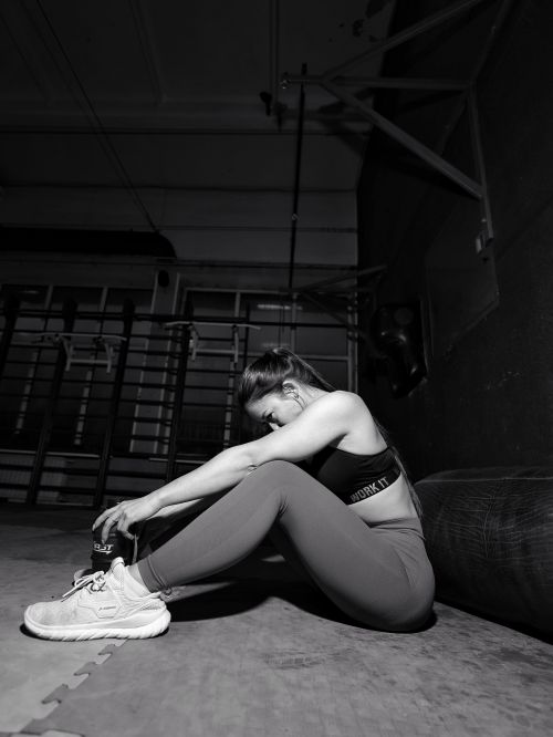 Free Young woman resting after workout in a gym, captured in a black and white style. Stock Photo
