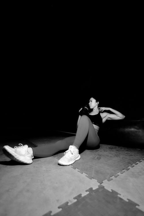 Free Woman in sportswear performing sit-ups in a gym setting. Stock Photo
