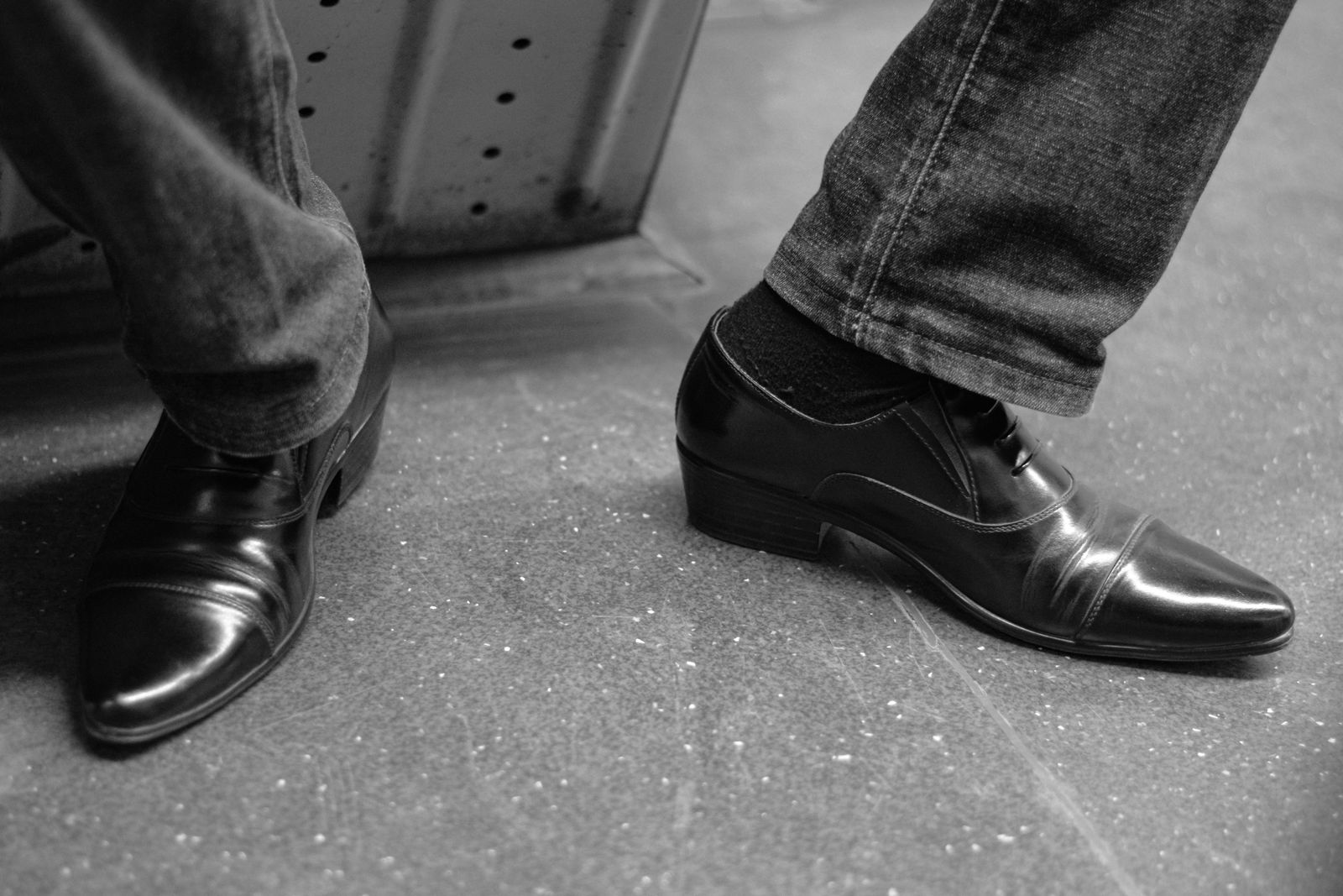 Paire d'oxfords marron en cuir patiné posés sur parquet en bois clair, embauchoirs visibles, ambiance vestiaire éditoriale