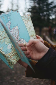 Close-up of hands holding a map in a forest setting, ideal for navigation concepts.