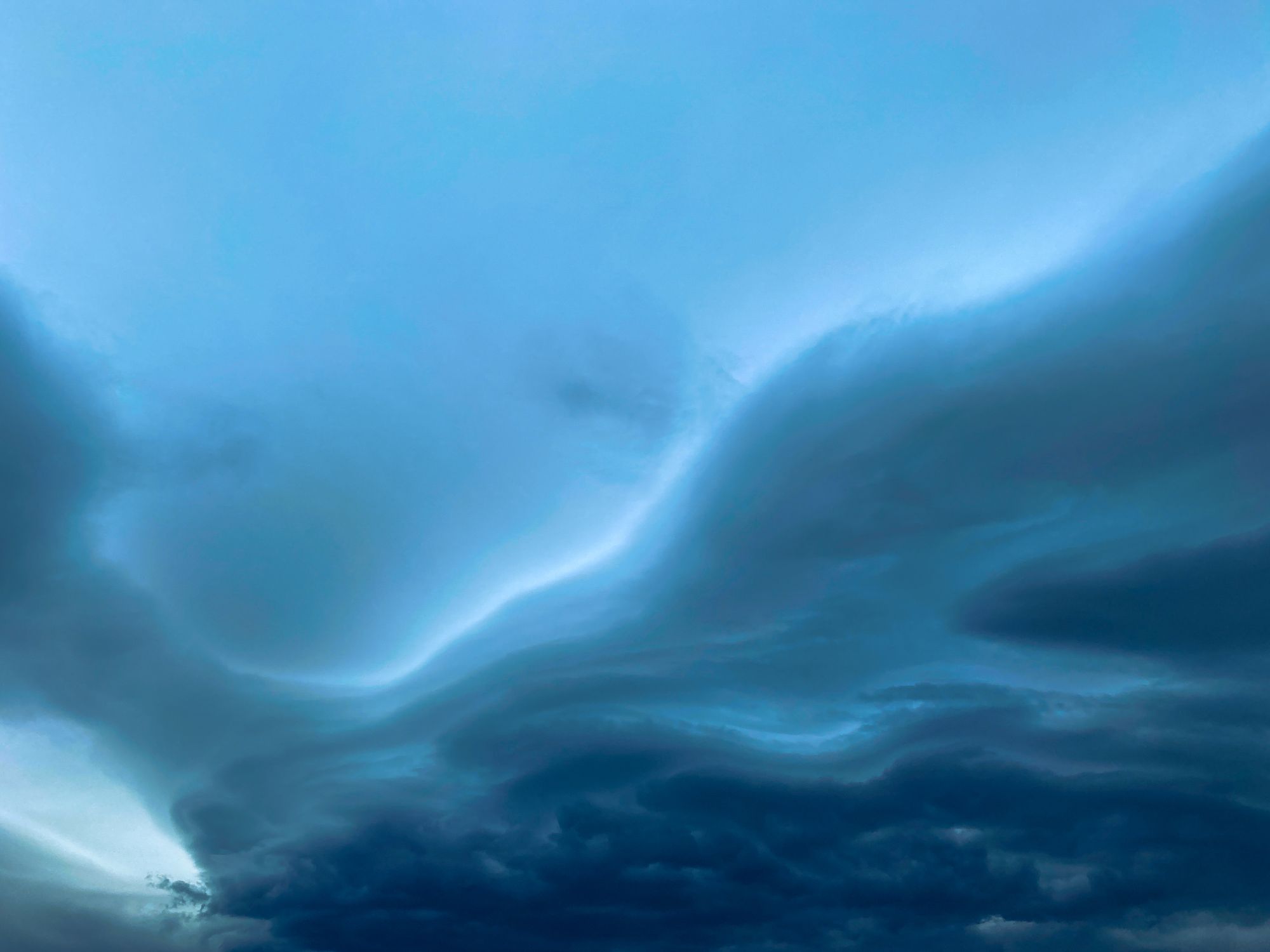 Formación de nubes con forma de olas rompientes alineadas en el cielo