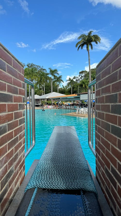 A pool with a slide and a brick wall