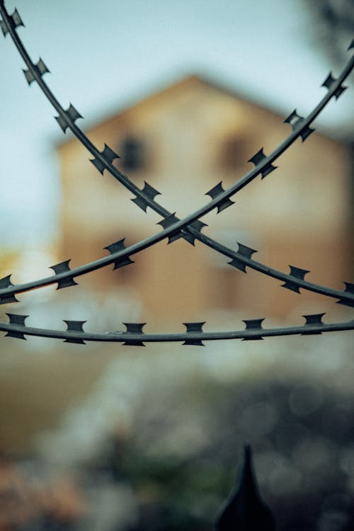 Barbed wire with a house in the background