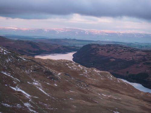 A view of a lake and mountains from a hill