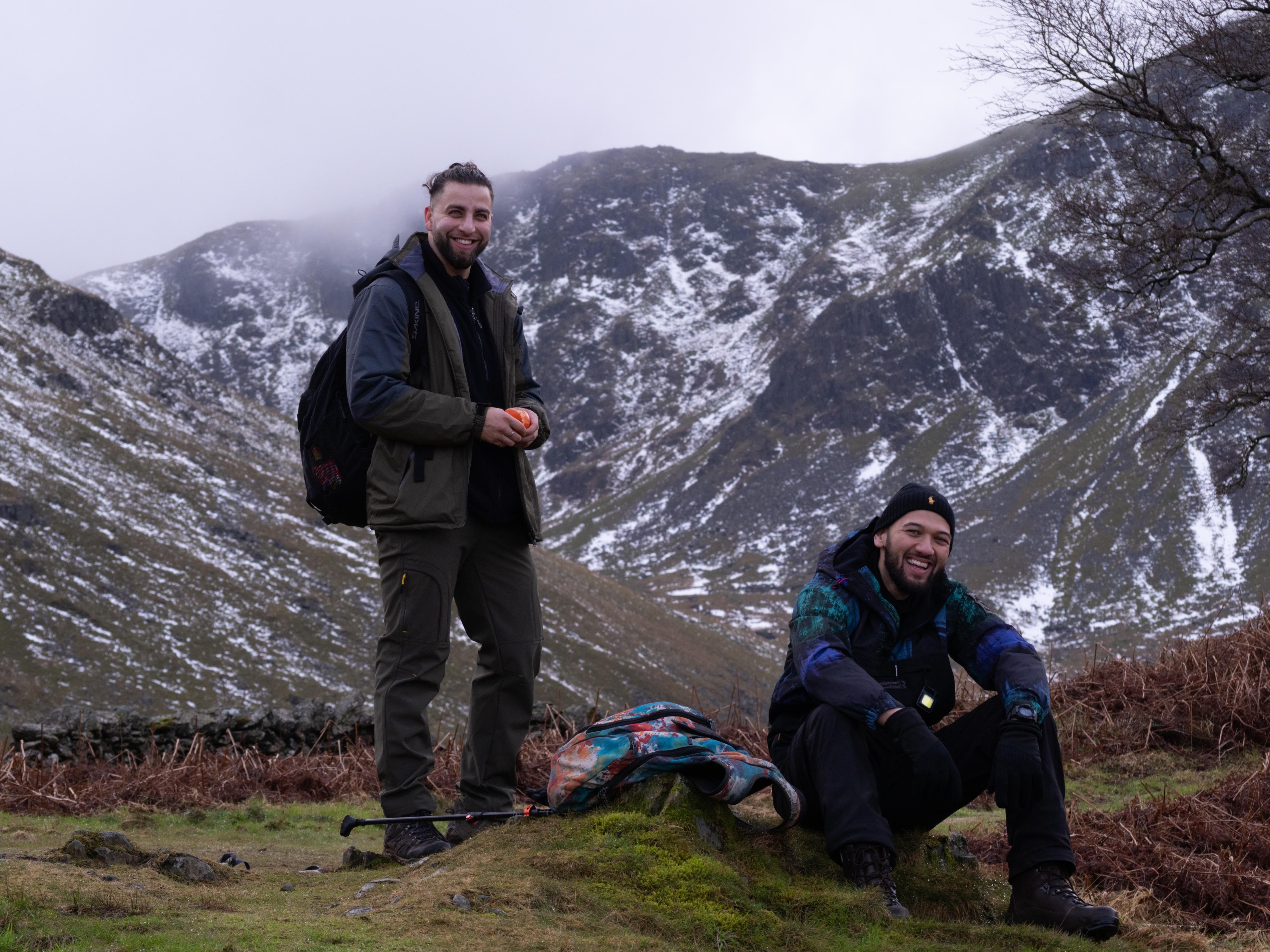 Two hikers enjoy a snowy mountain landscape, showcasing winter adventure and exploration.