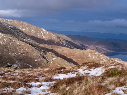 A snowy mountain with a lake and snow covered hills