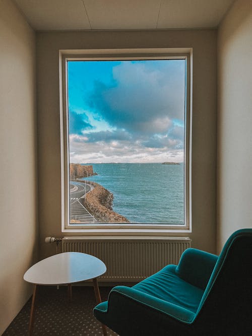 A chair sitting in front of a window overlooking the ocean