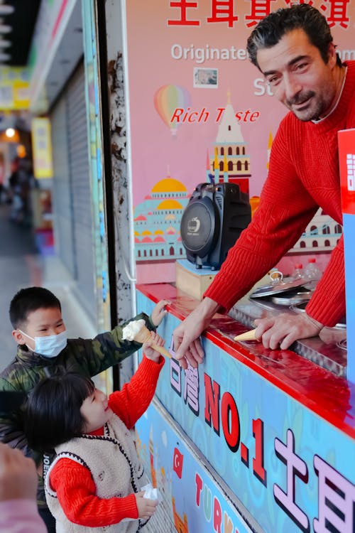 Man Selling Ice Cream to Children 