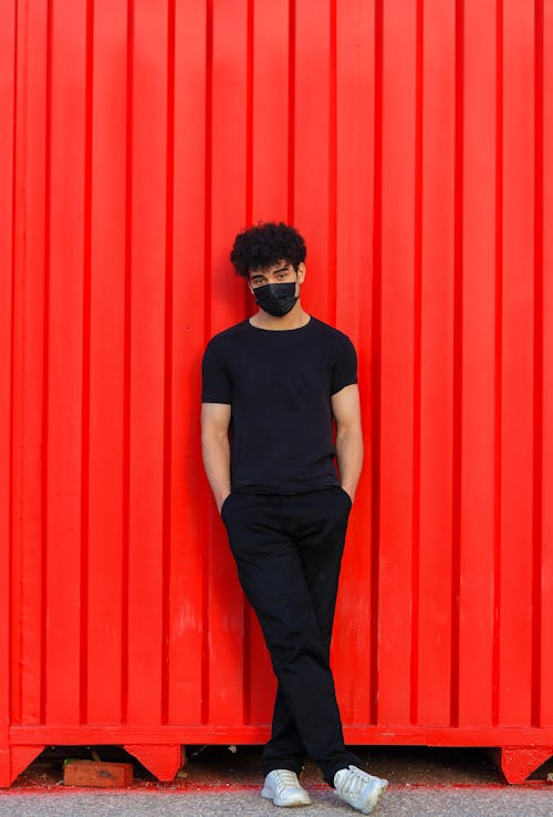 Man in Black by Red Wall