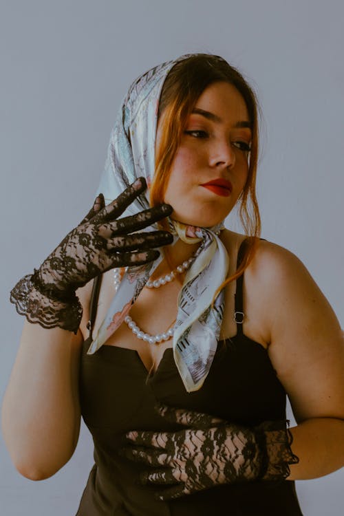 A woman in black lace gloves and a scarf