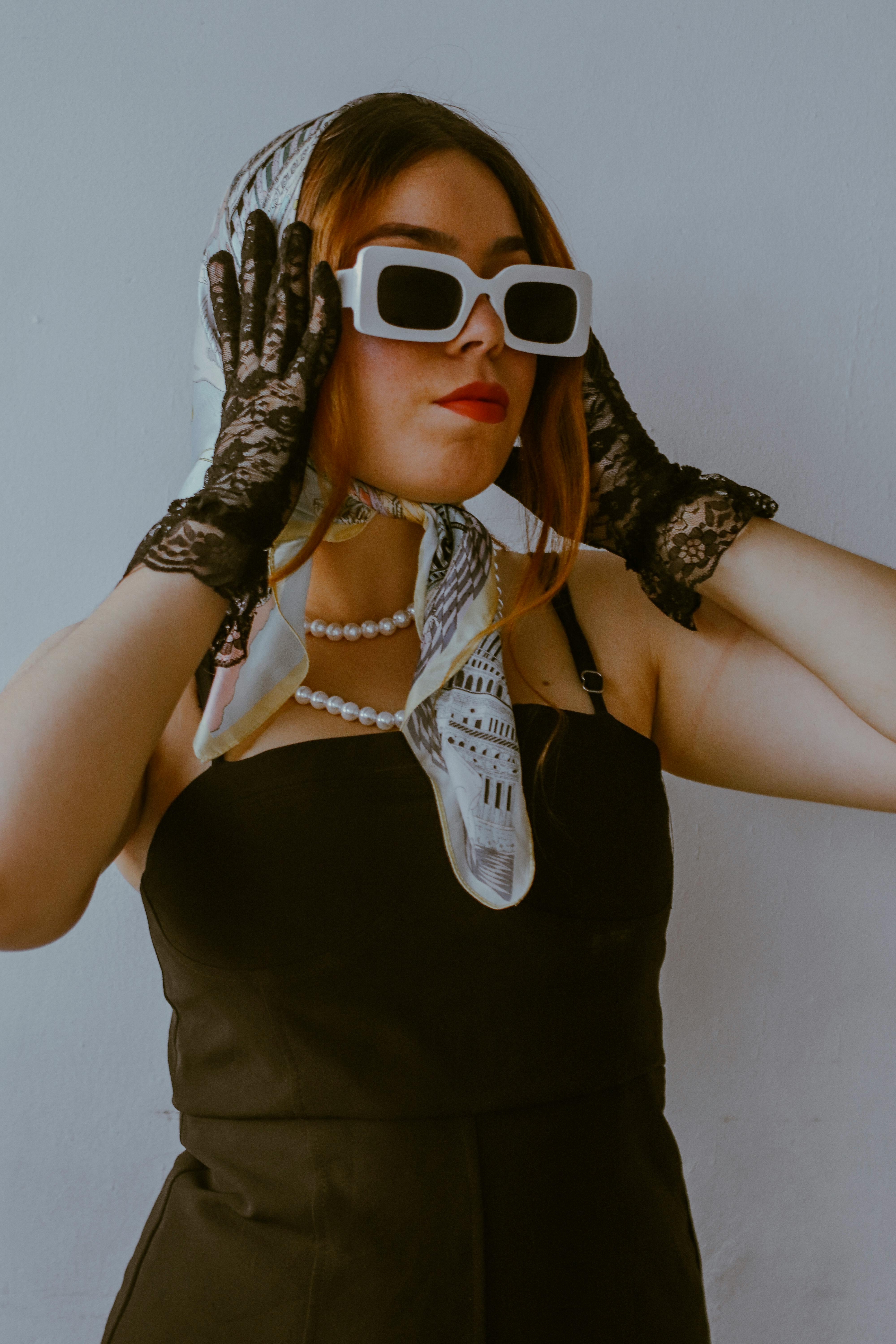 Free Elegant woman in black dress with pearls and headscarf exudes vintage style. Stock Photo