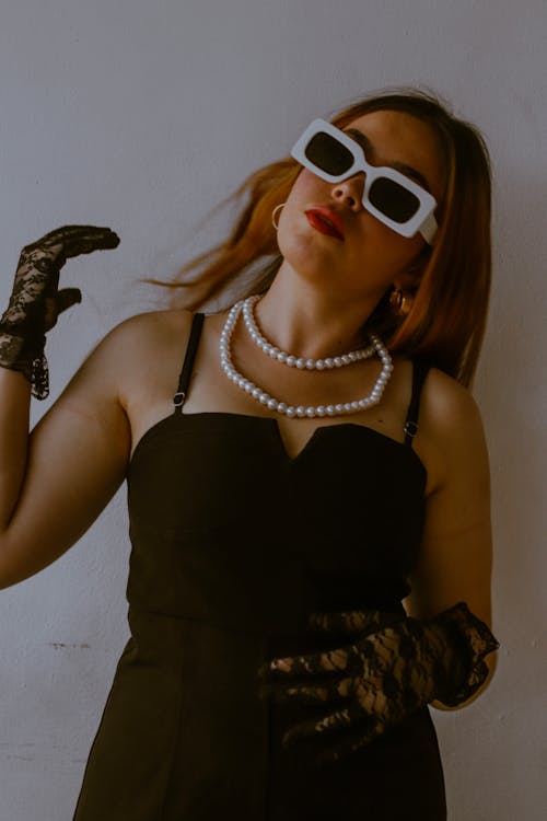 A woman in black and white dress and sunglasses