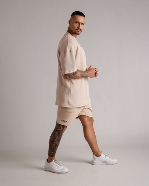 Man with Tattoos Standing in T-shirt and Shorts