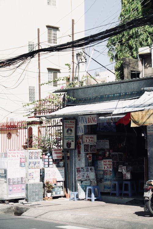 Free Vibrant street view showcasing a local storefront with signage and surrounding urban environment in Vietnam. Stock Photo