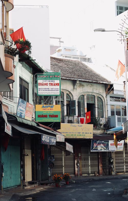 Free Charming view of a Vietnamese street with traditional buildings and flags, capturing urban culture. Stock Photo