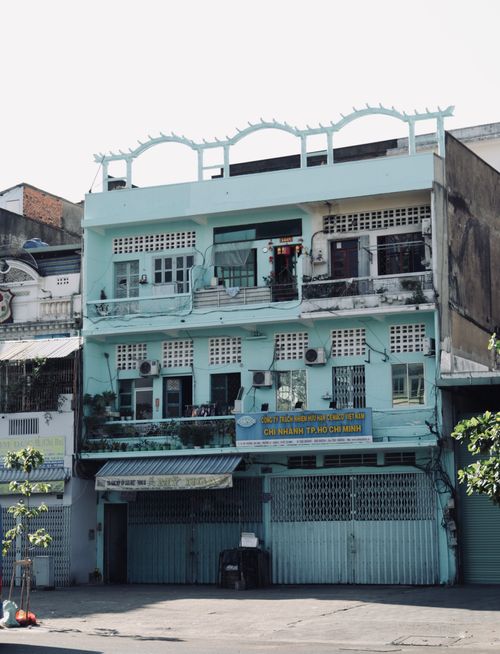 Free A three-story building in Ho Chi Minh City showcasing classic Vietnamese architecture on a sunny day. Stock Photo