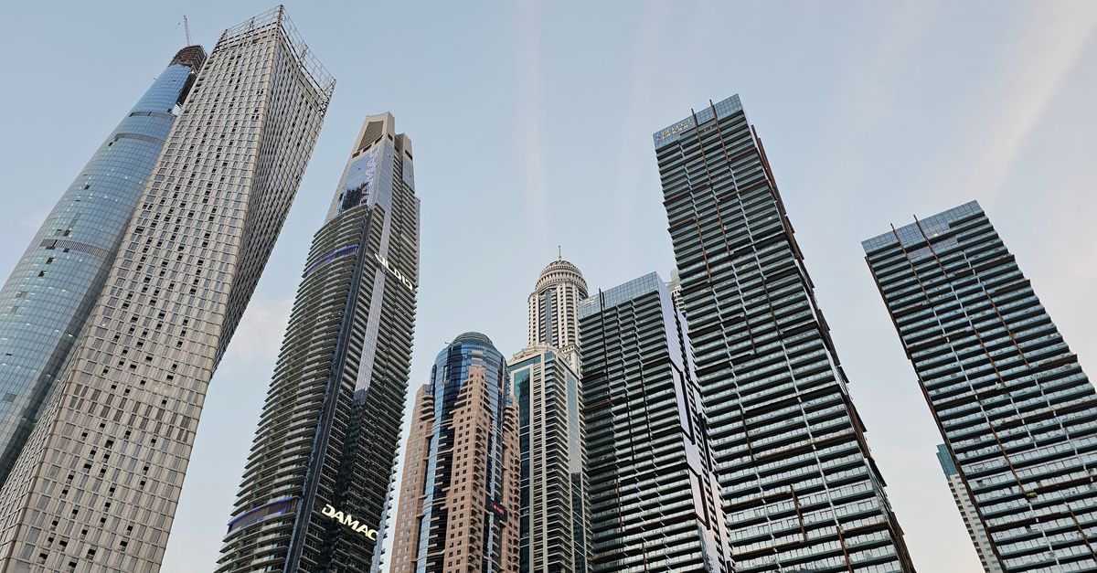 Low angle view of modern skyscrapers in Dubai's urban skyline during the day.