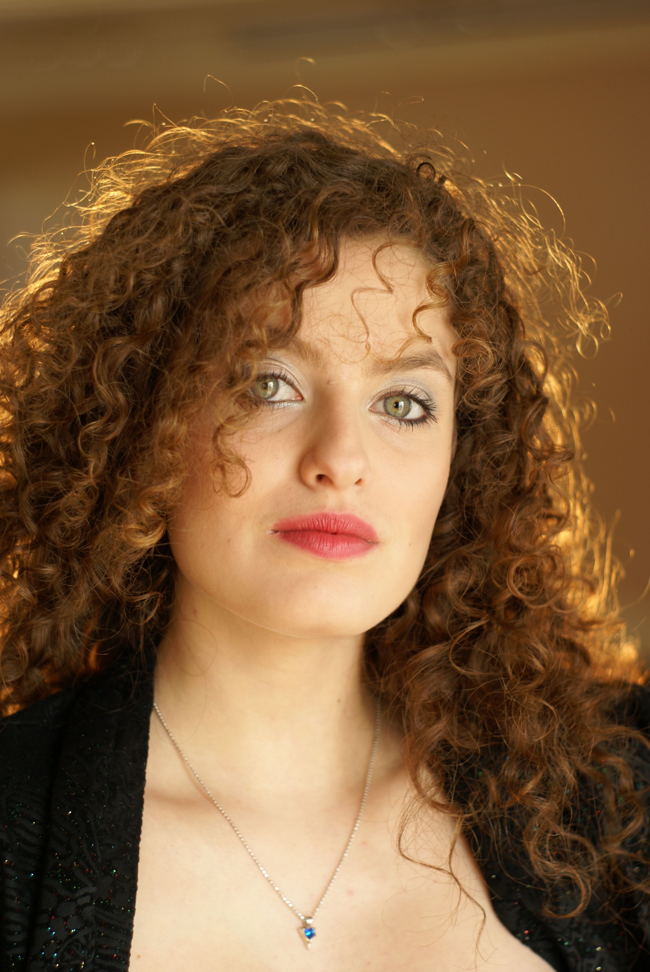 A woman with curly hair and a black jacket · Free Stock Photo